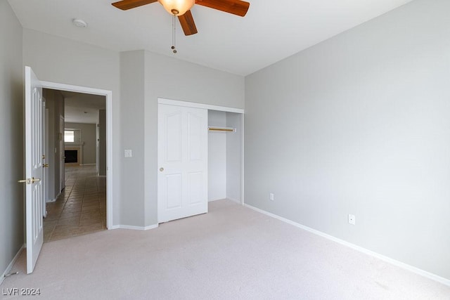 unfurnished bedroom with a ceiling fan, light colored carpet, baseboards, and a closet