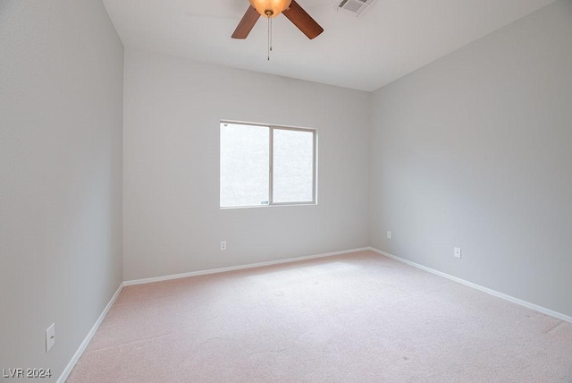 spare room with visible vents, light colored carpet, baseboards, and ceiling fan