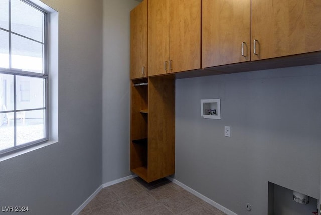 laundry room featuring baseboards, cabinet space, hookup for a washing machine, and light tile patterned flooring