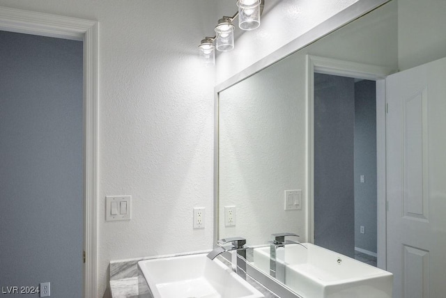 bathroom with a textured wall and a sink