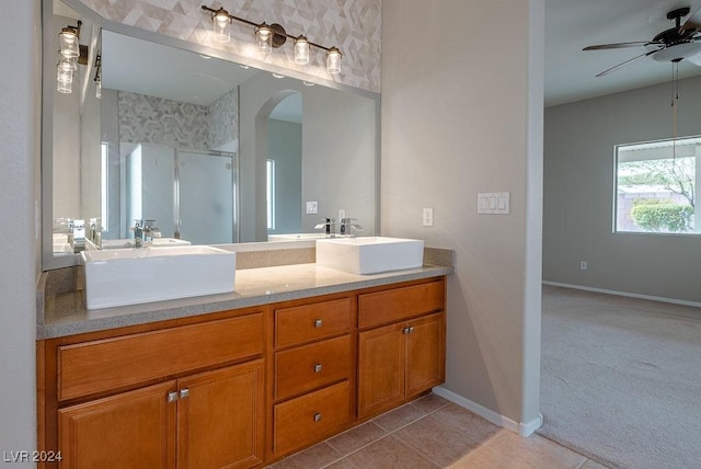 full bathroom featuring a ceiling fan, a shower stall, double vanity, and a sink