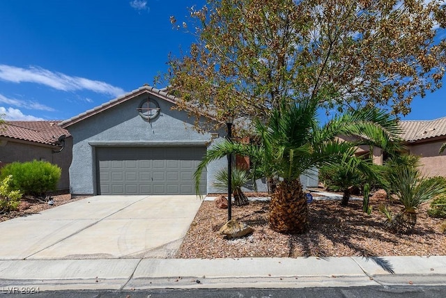 view of front facade featuring stucco siding, concrete driveway, an attached garage, and a tile roof