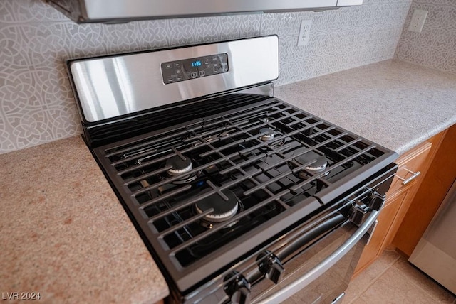 interior details with stainless steel gas stove and light countertops