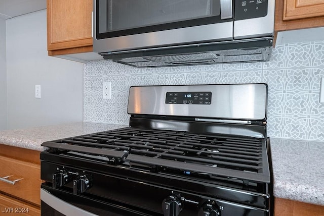 details with light stone counters, stainless steel appliances, and tasteful backsplash