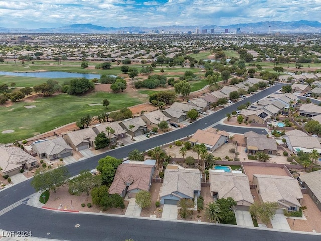 aerial view featuring view of golf course, a residential view, and a water and mountain view