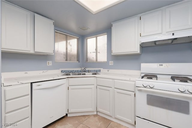 kitchen with white appliances, sink, light tile patterned floors, light stone counters, and white cabinetry