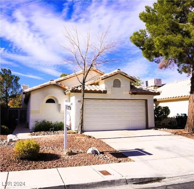 mediterranean / spanish-style home with a garage