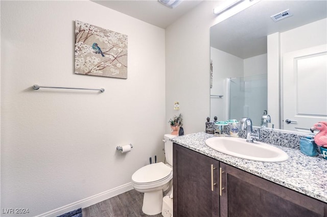 full bathroom with visible vents, toilet, a stall shower, wood finished floors, and vanity