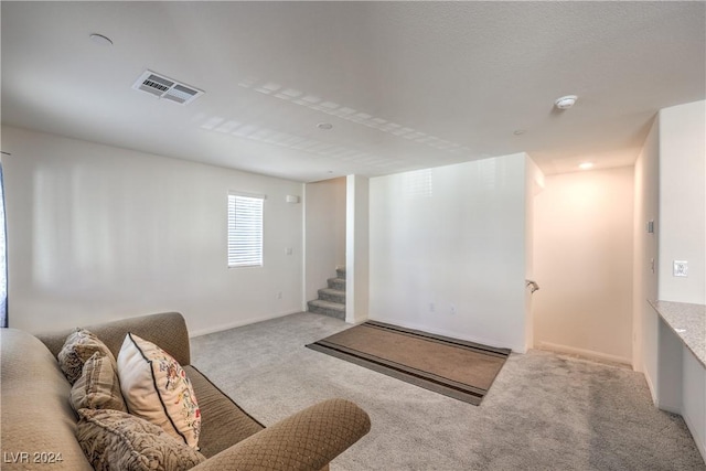 living room featuring visible vents, baseboards, carpet, and stairway