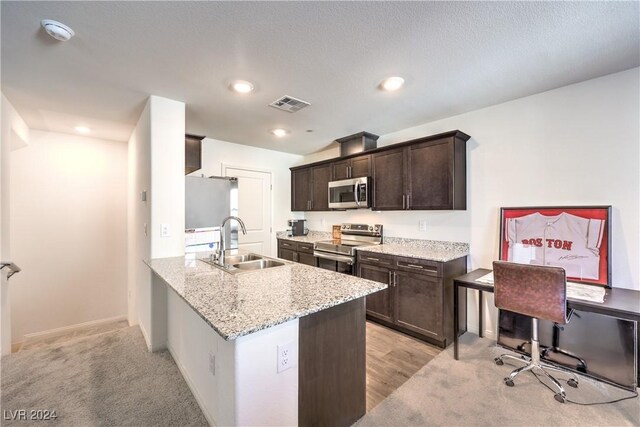 kitchen with visible vents, a sink, appliances with stainless steel finishes, light stone countertops, and dark brown cabinets