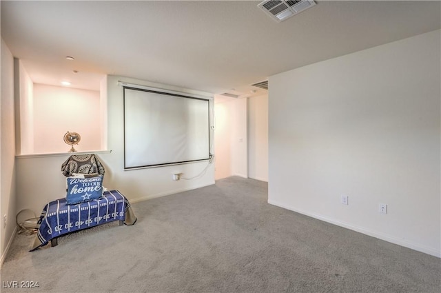 carpeted cinema room with visible vents and baseboards