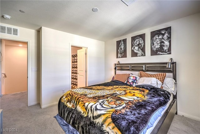 bedroom with visible vents, light carpet, and lofted ceiling