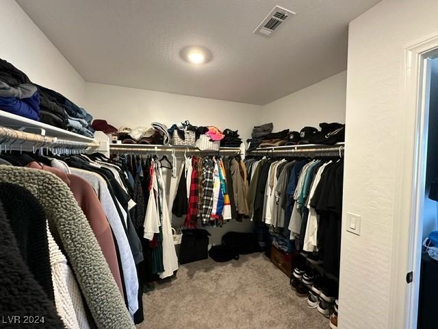 walk in closet with carpet floors and visible vents