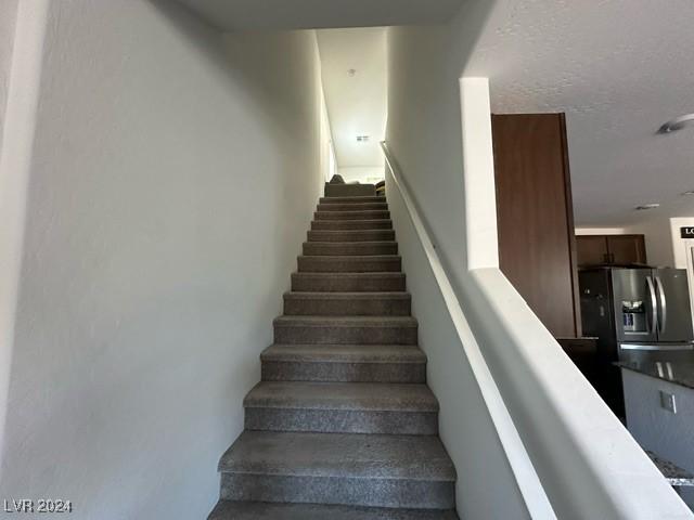 stairway with a textured ceiling