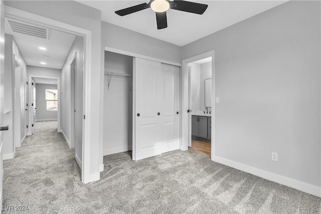 unfurnished bedroom featuring a closet, light colored carpet, and ceiling fan