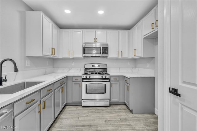 kitchen with gray cabinets, light stone countertops, sink, and appliances with stainless steel finishes