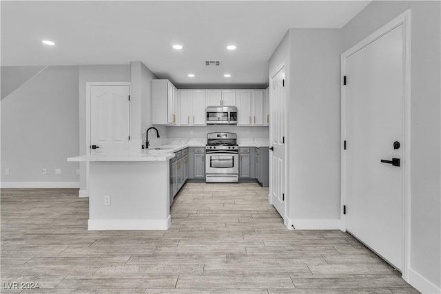 kitchen with light stone countertops, sink, and appliances with stainless steel finishes