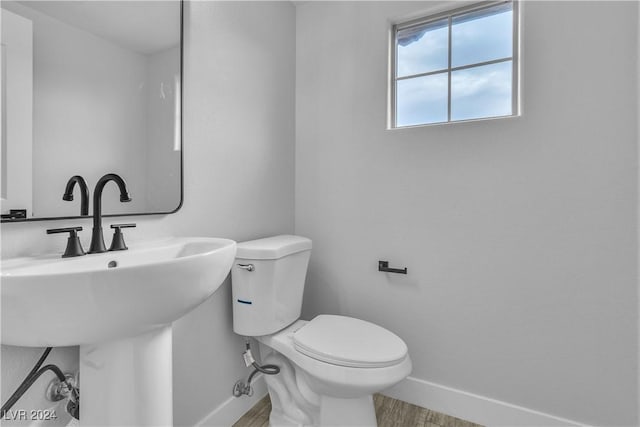 bathroom featuring sink, wood-type flooring, and toilet