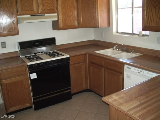 kitchen featuring white appliances, sink, and light tile patterned floors