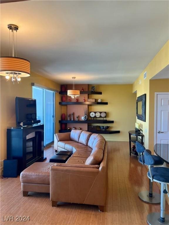 living room featuring light wood-type flooring and a chandelier