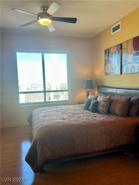 bedroom featuring multiple windows, hardwood / wood-style flooring, and ceiling fan