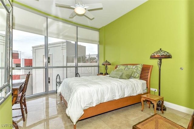 bedroom featuring baseboards, tile patterned floors, and expansive windows