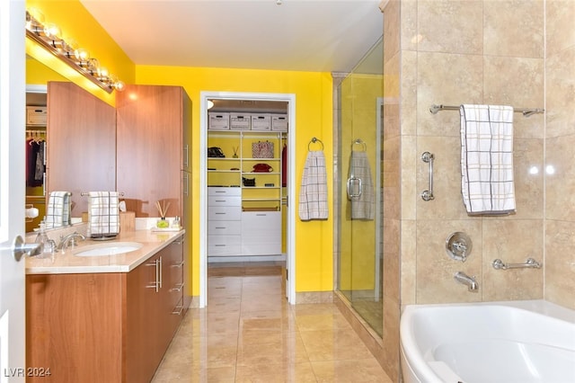 full bath featuring a shower stall, tile patterned floors, vanity, a walk in closet, and a bathing tub
