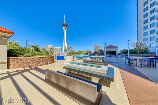 surrounding community featuring a patio and an outdoor bar