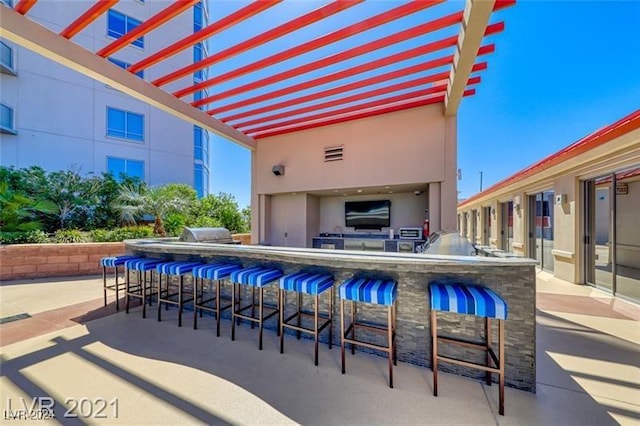 view of patio featuring visible vents, area for grilling, and outdoor wet bar