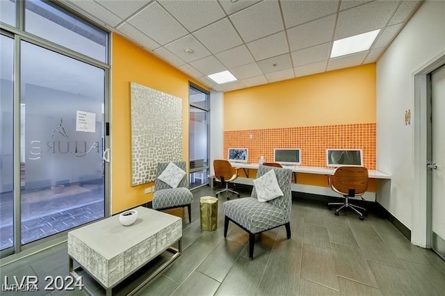 home office with built in study area and a drop ceiling