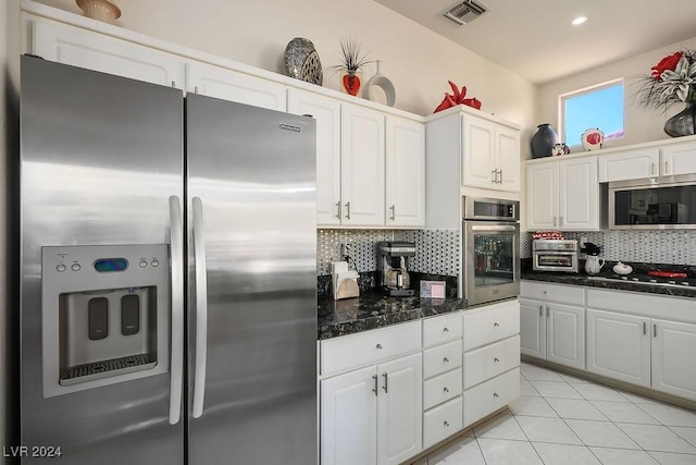 kitchen with light tile patterned floors, white cabinetry, appliances with stainless steel finishes, and tasteful backsplash