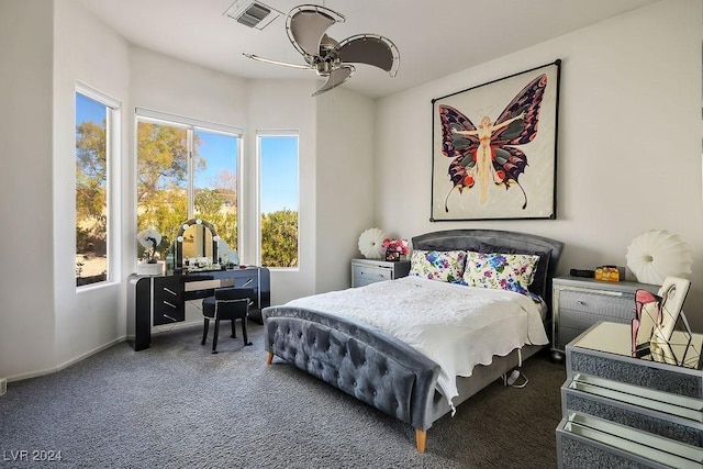 carpeted bedroom featuring ceiling fan and multiple windows