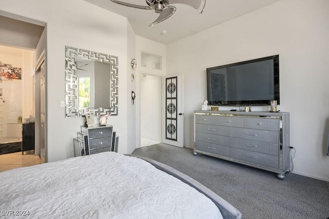 carpeted bedroom featuring ensuite bath and ceiling fan