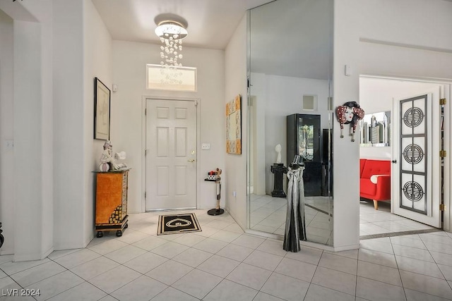 tiled foyer featuring a chandelier and a high ceiling