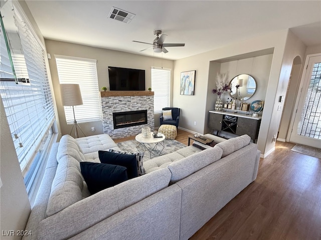 living room with hardwood / wood-style floors, ceiling fan, and a fireplace