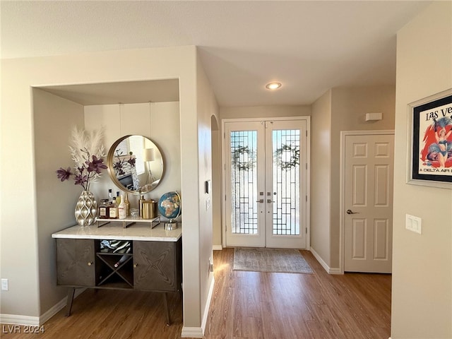 foyer entrance with hardwood / wood-style flooring and french doors