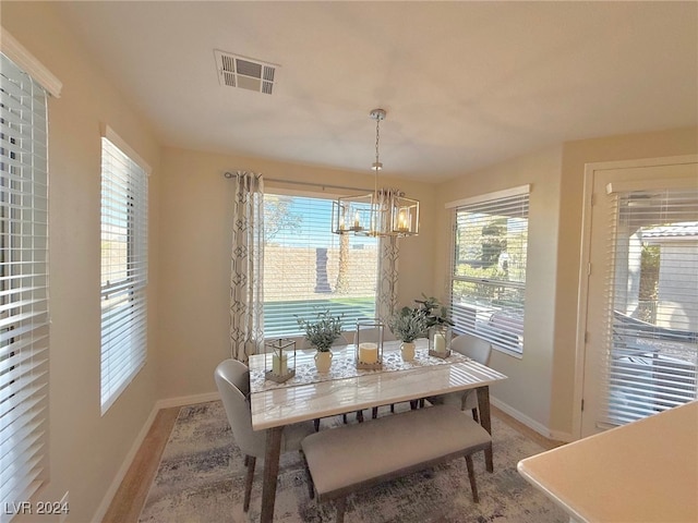 dining room featuring plenty of natural light, light hardwood / wood-style flooring, and an inviting chandelier