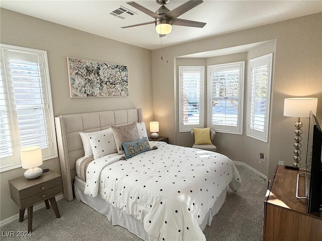 carpeted bedroom with multiple windows and ceiling fan