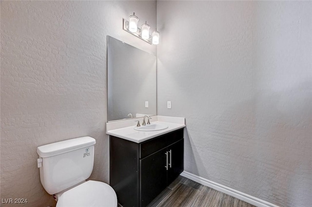 bathroom with hardwood / wood-style floors, vanity, and toilet