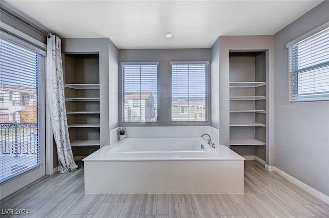 bathroom with a bathing tub and built in features