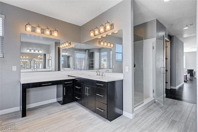 bathroom with vanity, an enclosed shower, and a textured ceiling