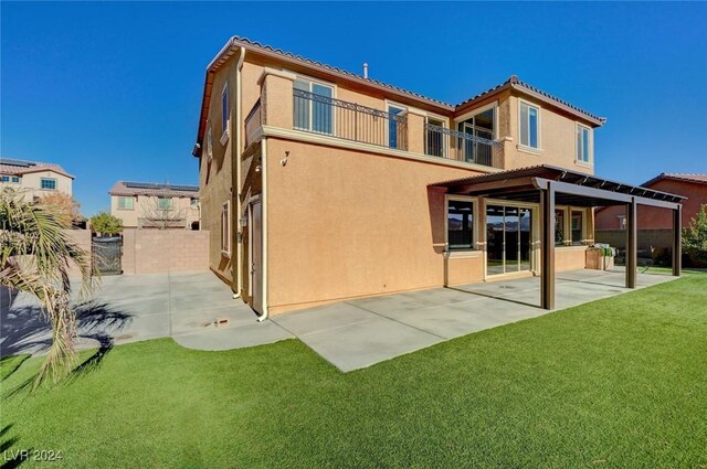 back of house with a yard, a patio area, and a balcony