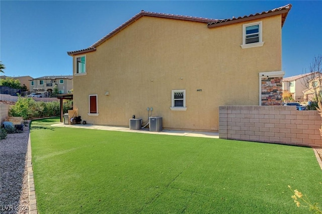 back of house featuring a yard and central air condition unit