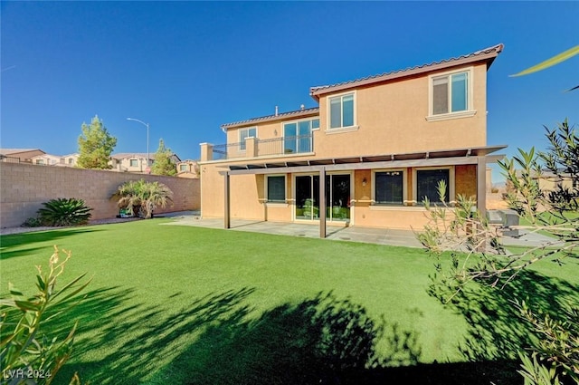 rear view of property with a yard and a patio