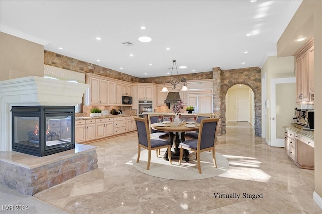 dining area with a multi sided fireplace and crown molding