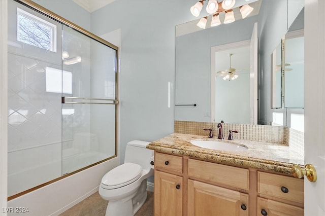 full bathroom featuring ceiling fan, tasteful backsplash, combined bath / shower with glass door, toilet, and vanity