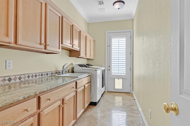 washroom featuring cabinets, separate washer and dryer, sink, and ornamental molding