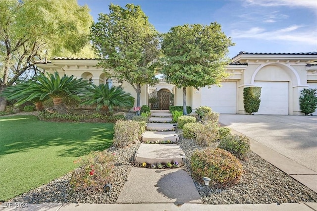 mediterranean / spanish-style home featuring a front yard and a garage