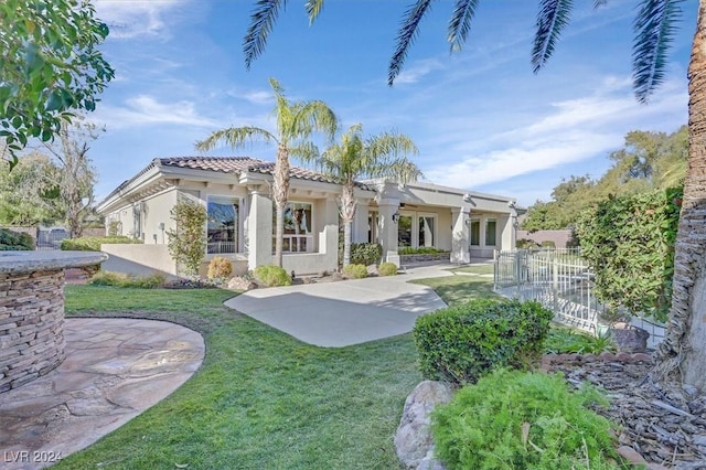 rear view of house featuring a patio area and a yard