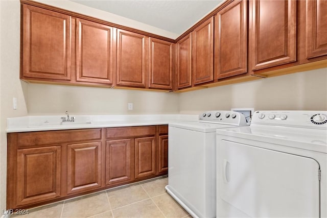 laundry room with sink, light tile patterned floors, cabinets, and independent washer and dryer